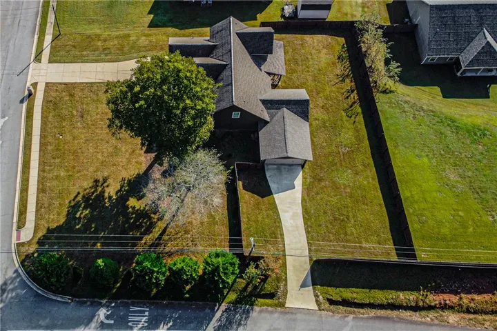An aerial perspective reveals the expansive lawn and complete perimeter fencing wrapping this private property.