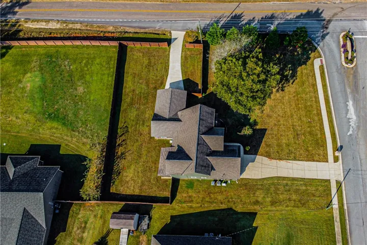 An aerial perspective showcases the spacious lot layout, secure fencing, and concrete driveways.