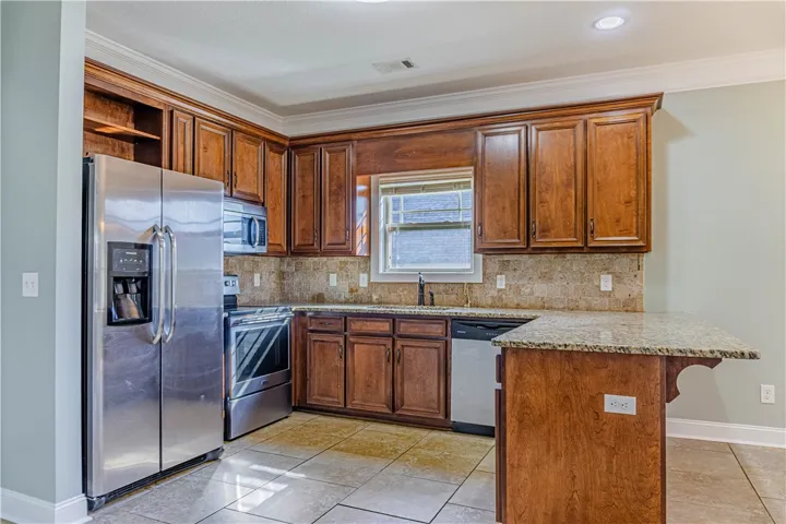 Rich wood cabinetry paired with stone countertops defines this classic kitchen space.