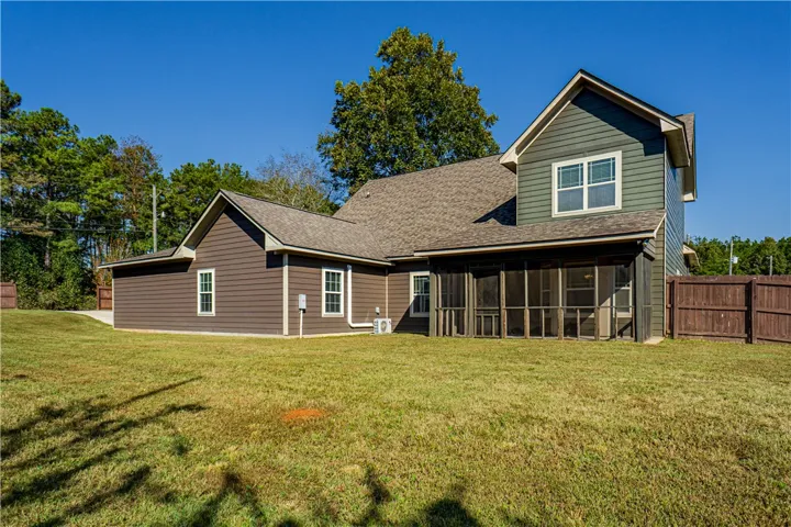 An inviting backyard lawn leads to a screened porch beneath gabled shingle rooflines.