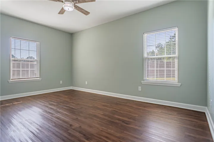 Rich wood-look flooring and dual windows create a peaceful and open atmosphere.