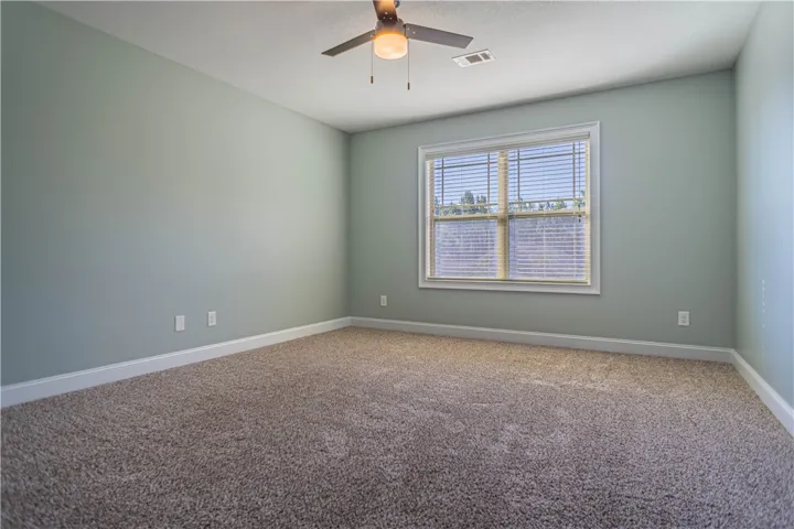 Plush carpeting and a large window facing the trees highlight this comfortable bedroom space.