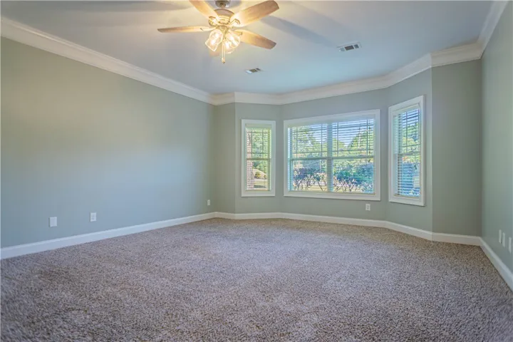 Crown molding and a bay window highlight this versatile living space.