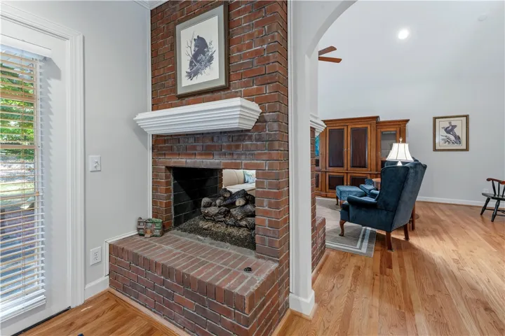 Rich hardwood floors lead past a dual-sided brick fireplace into an inviting living space.