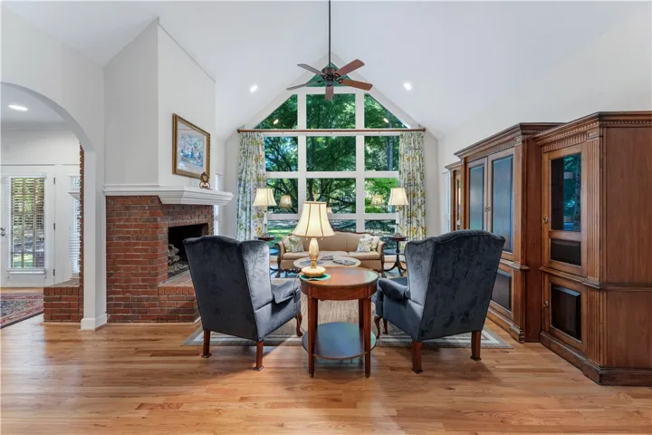 A classic brick fireplace and soaring vaulted ceilings define this inviting living space.