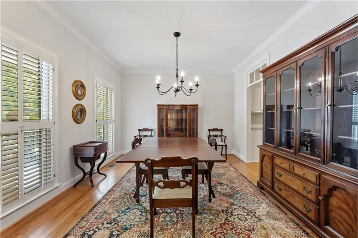 Crown molding and rich hardwood flooring frame a classic dining space designed for gathering.
