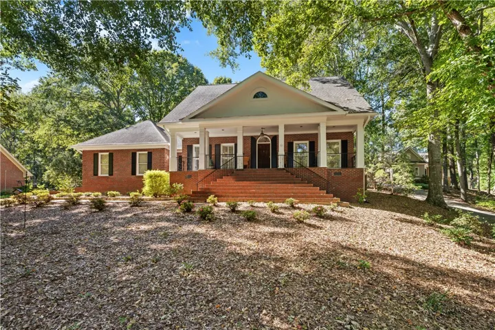 Stately columns and a grand brick staircase welcome you to this timeless brick residence.