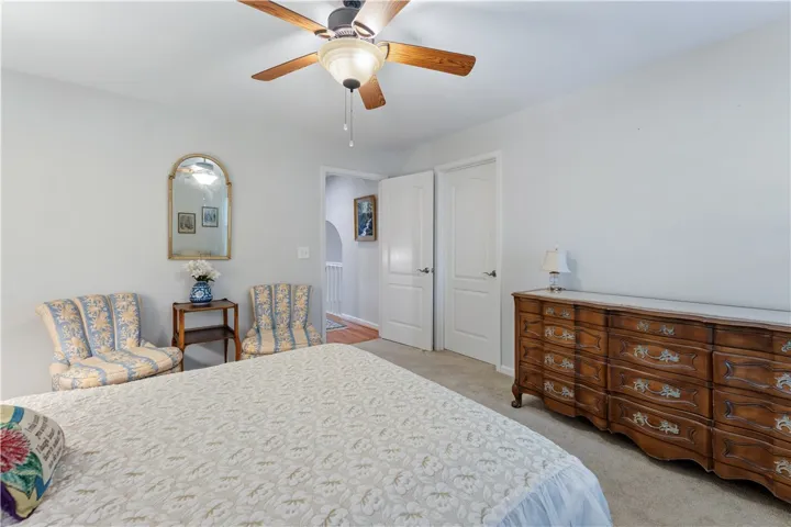Soft carpet and classic paneled doors define this comfortable, light-filled bedroom layout.