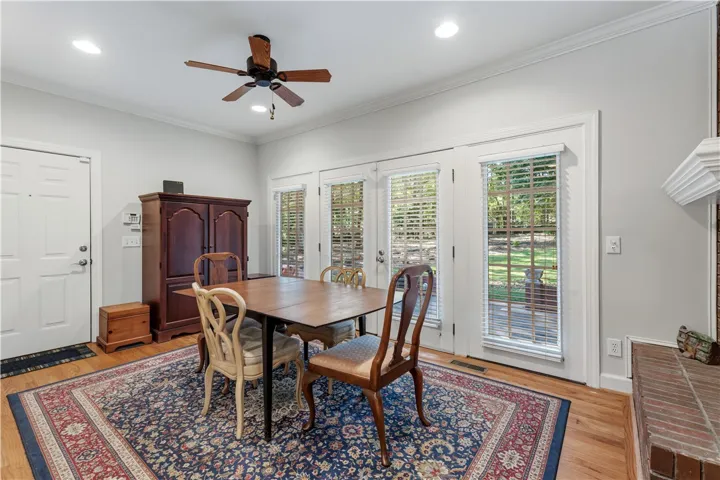 Rich hardwood flooring complements crown molding and expansive glass doors leading outdoors.