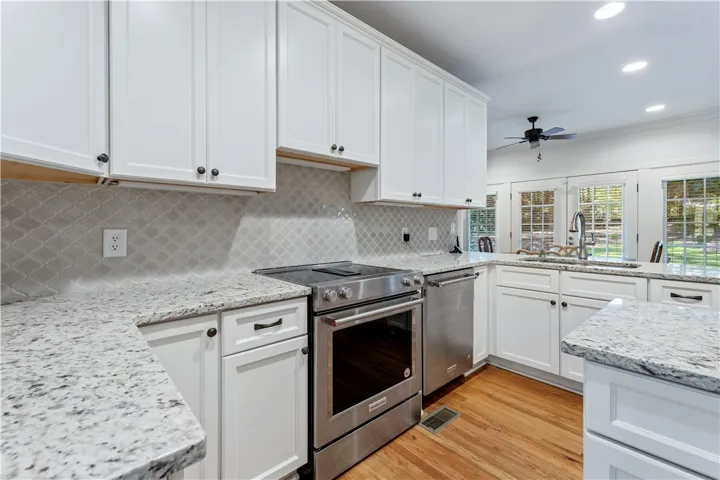 Polished granite countertops and classic shaker cabinetry anchor this well-appointed kitchen workspace.