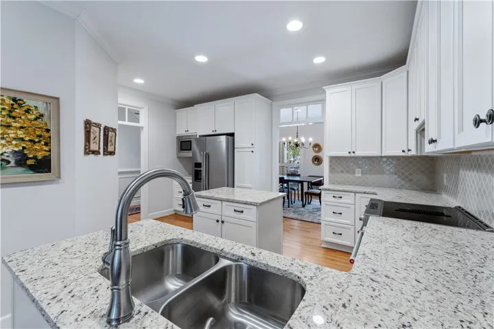 Gleaming granite countertops pair beautifully with classic cabinetry and warm wood flooring.