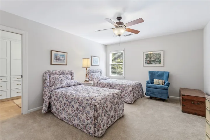 Soft carpet and natural window light define this comfortable secondary bedroom.