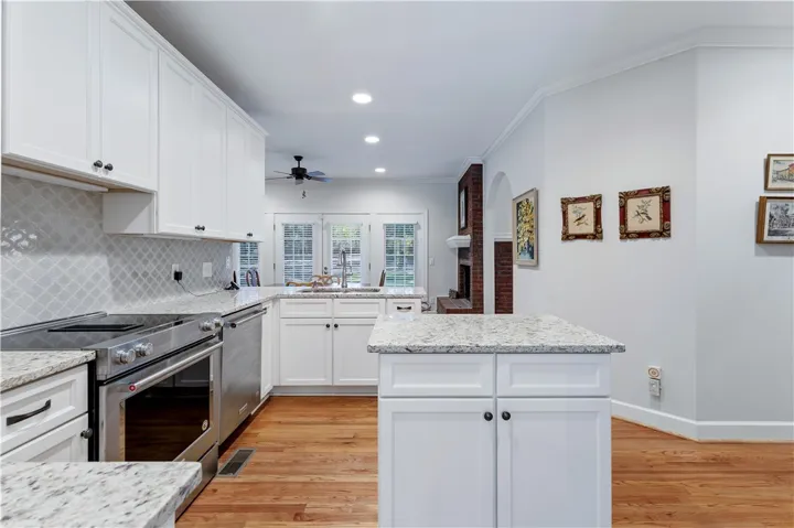 Rich hardwood floors contrast beautifully with crisp white cabinetry and classic stone countertops.
