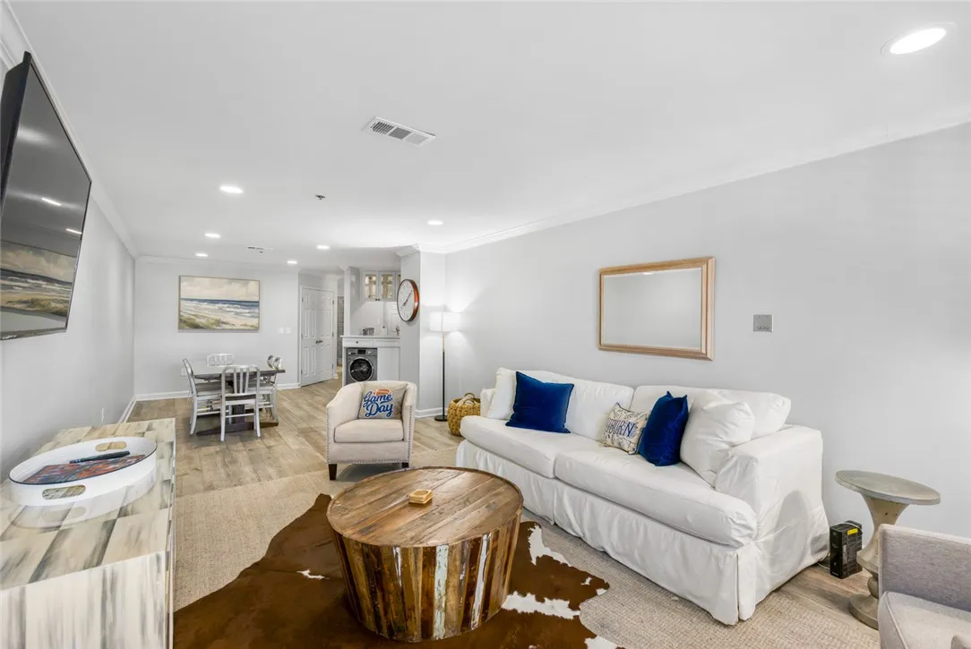 Smooth wood-look flooring and crown molding accent this open-concept main living area.