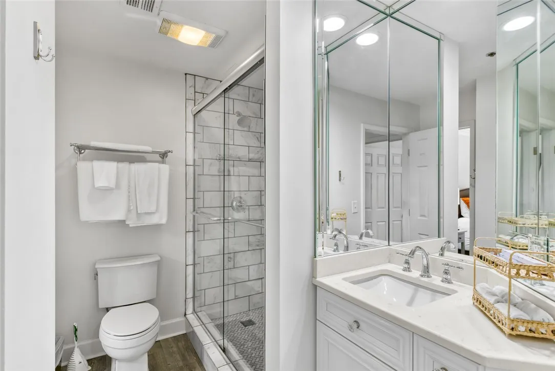A modern vanity with stone counters complements the beautifully tiled walk-in glass shower.