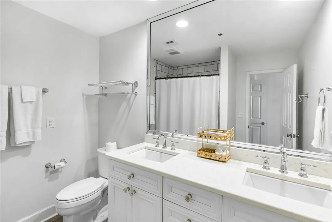 Clean lines and a double vanity define this updated primary bathroom space.