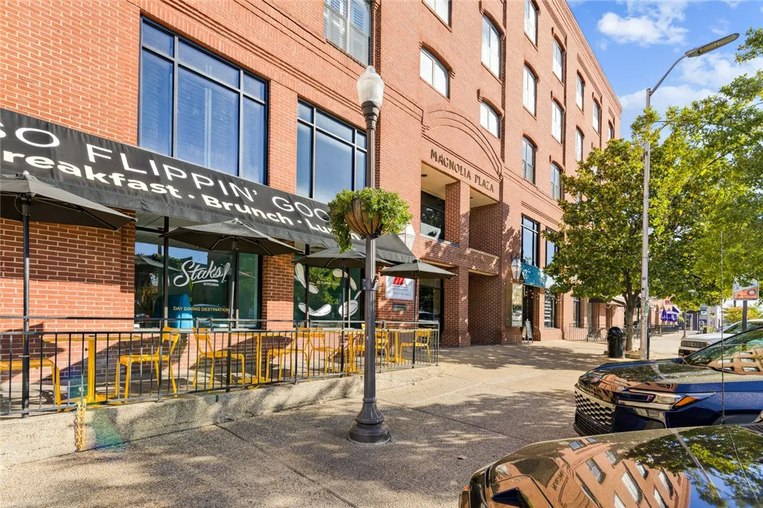 Classic brick architecture defines this vibrant multi-story building situated along a tree-lined street.