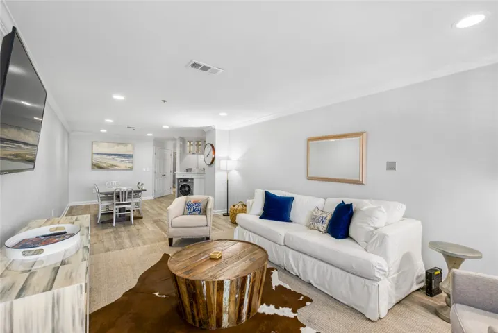Smooth wood-look flooring and crown molding accent this open-concept main living area.