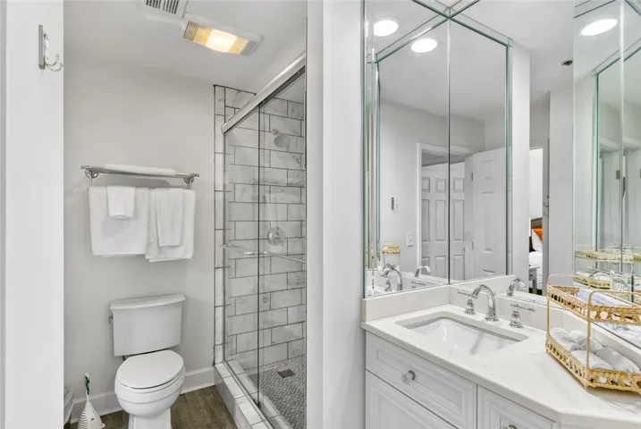 A modern vanity with stone counters complements the beautifully tiled walk-in glass shower.