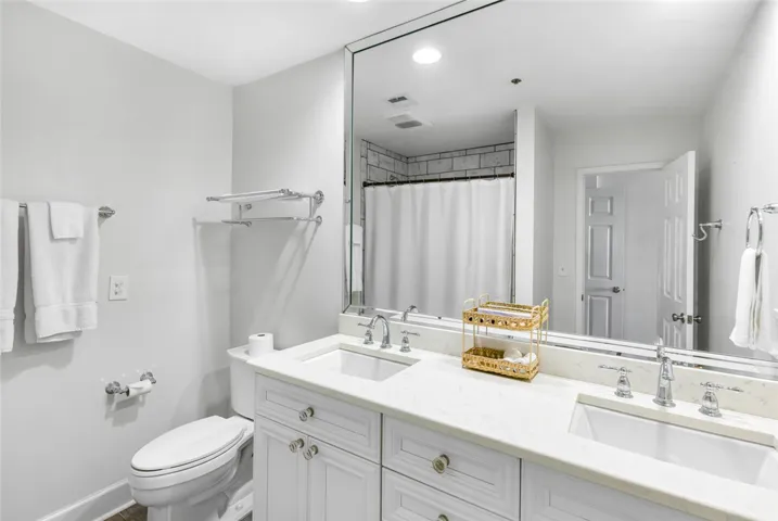 Clean lines and a double vanity define this updated primary bathroom space.