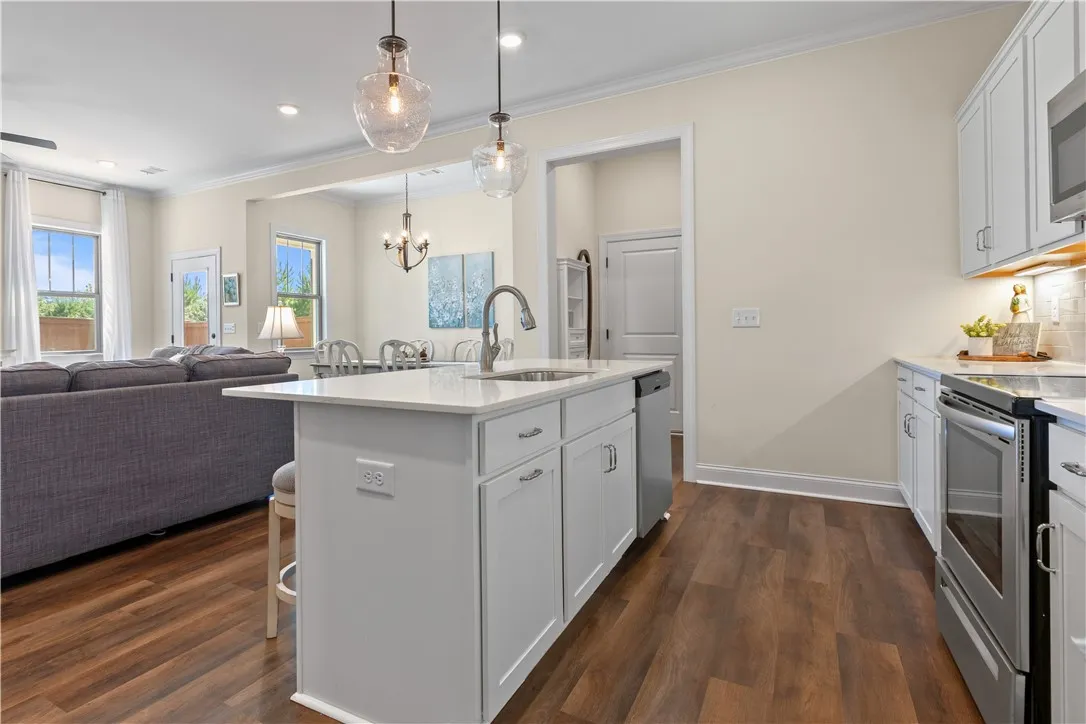 An open floorplan seamlessly connects the modern kitchen and central island to the living areas.