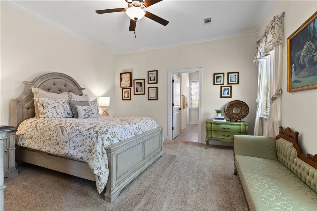 Soft carpeting pairs with classic crown molding in this peaceful bedroom retreat.