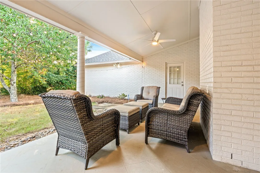 Sheltered back porch features smooth concrete flooring and classic painted brick siding.