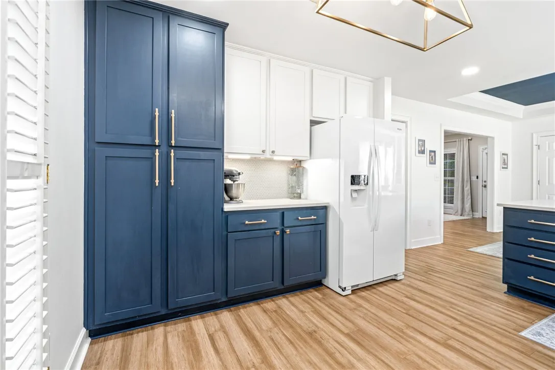 Richly toned wooden floors and custom cabinetry anchor this bright, inviting kitchen workspace.