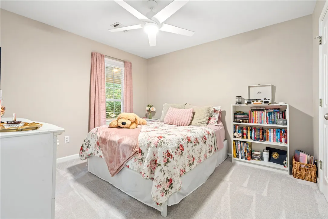 Soft carpet and clean architectural lines create a comfortable, inviting secondary bedroom.