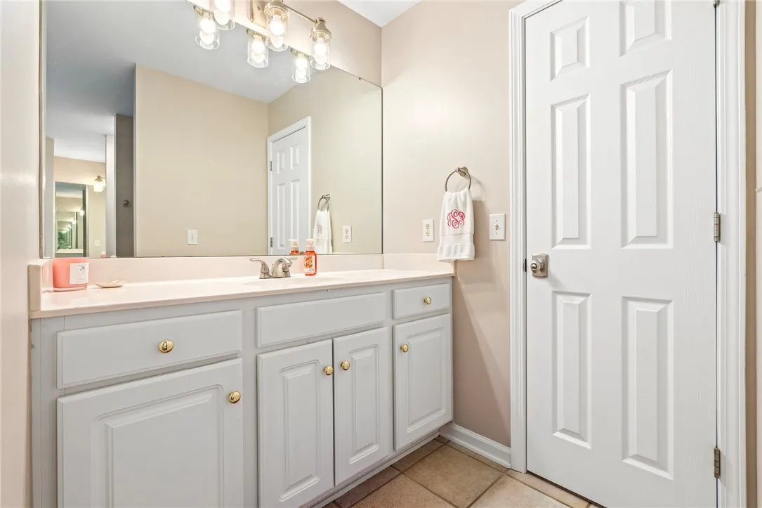A spacious vanity with ample storage sits beneath a large wall-spanning mirror.