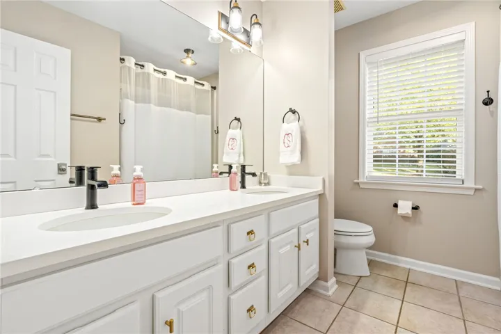 A spacious double vanity and classic tiled flooring define this bright, functional bathroom layout.