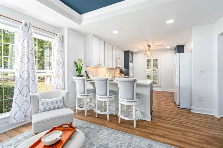An open kitchen layout features clean cabinetry, durable flooring, and elegant crown molding details.
