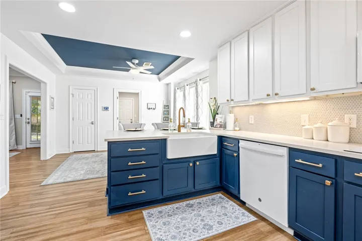 Modern cabinetry and stone counters anchor this updated culinary workspace with rich wood-patterned flooring.