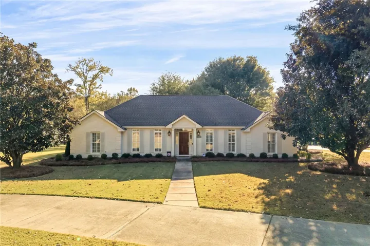 A classic brick exterior and manicured lawn create exceptional curb appeal.
