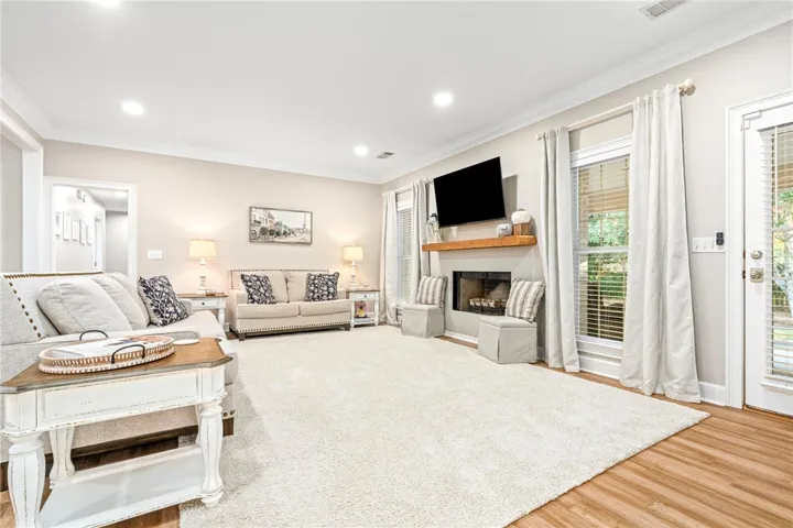 Elegant crown molding and warm wood flooring frame a classic living room centered around a fireplace.