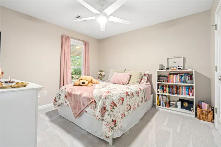 Soft carpet and clean architectural lines create a comfortable, inviting secondary bedroom.