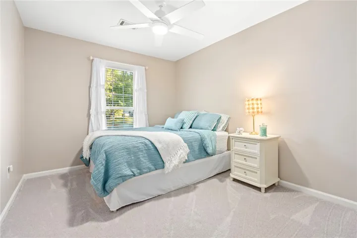 Soft carpeting pairs with a multi-pane window in this relaxing bedroom retreat.