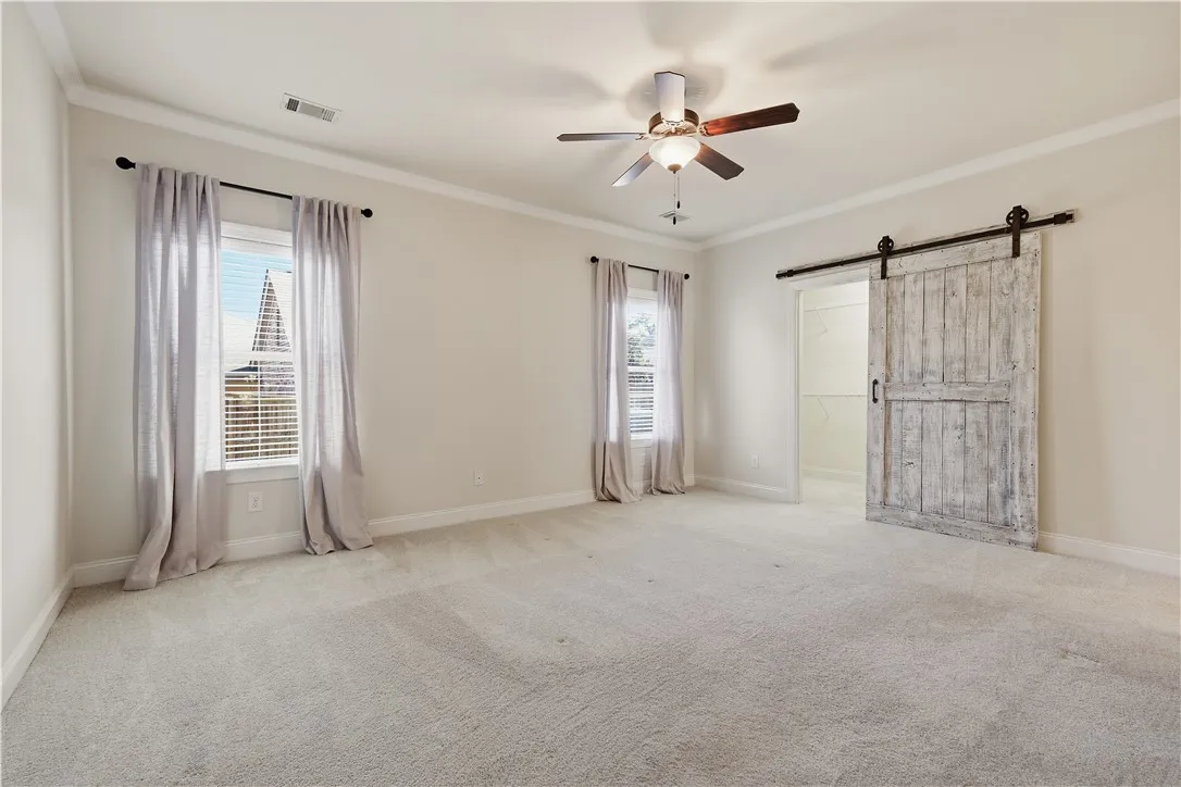 A barn door ads an architectural element to the primary bedroom.