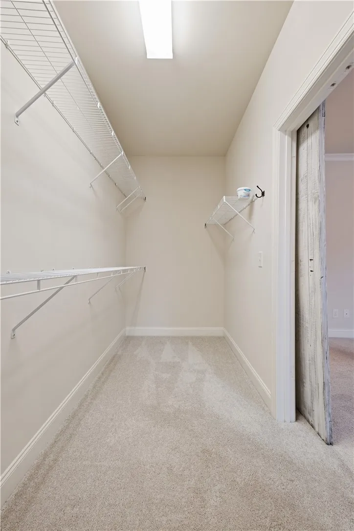 The spacious primary closet is tucked behind a barn door.