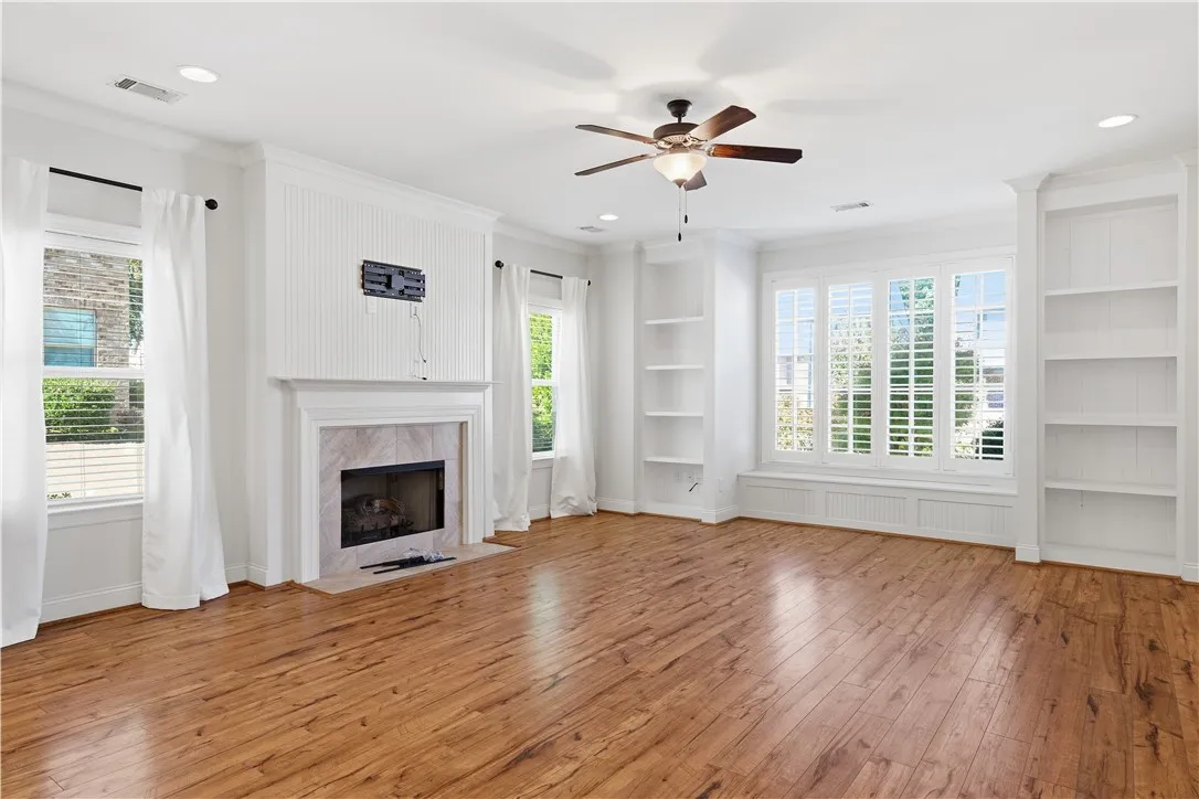 The living room features a wall of windows above a window seat, framed by custom built-ins.