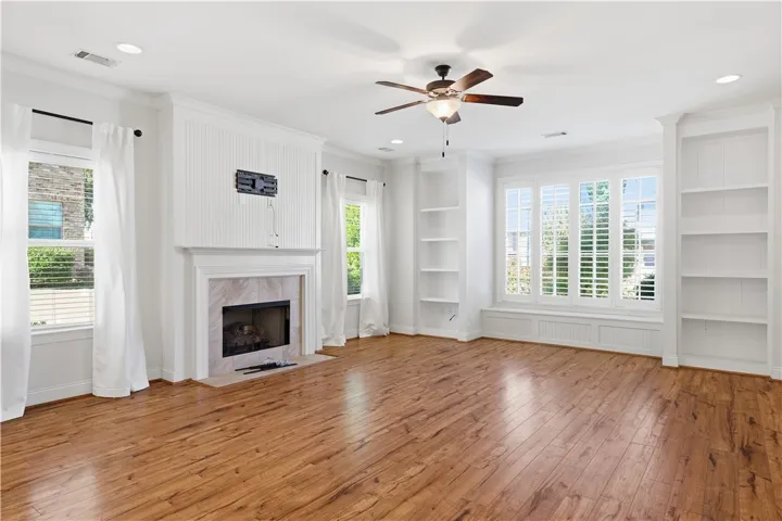 The living room features a wall of windows above a window seat, framed by custom built-ins.
