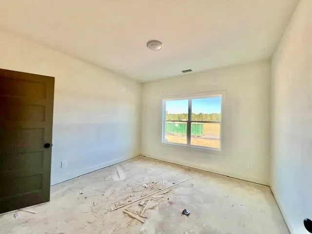 A single window frames outdoor views in this bedroom awaiting final flooring and finishes.