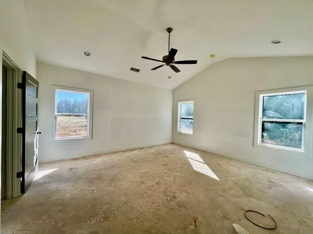An airy bedroom awaits customization, showcasing high vaulted ceilings and multiple view windows.