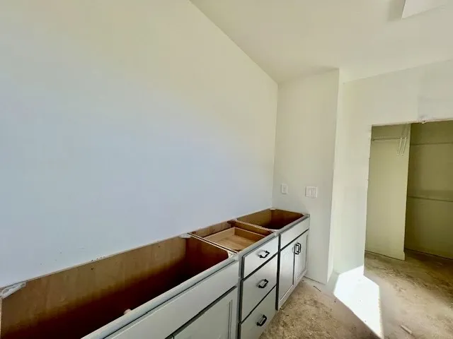 A spacious layout awaits completion in this bathroom with an adjoining walk-in closet.