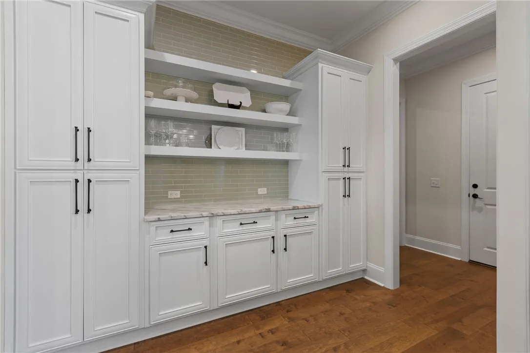 Gleaming hardwood floors and a customized butler pantry elevate this transitions space.