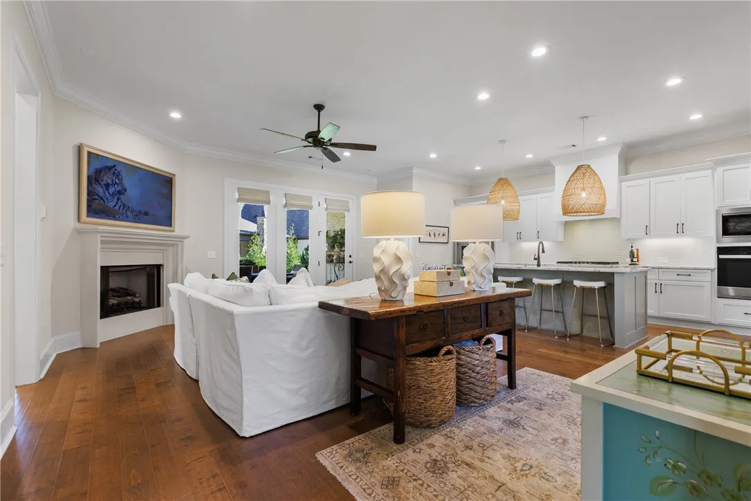 Rich hardwood floors and a classic fireplace anchor this seamless, light-filled open concept layout.