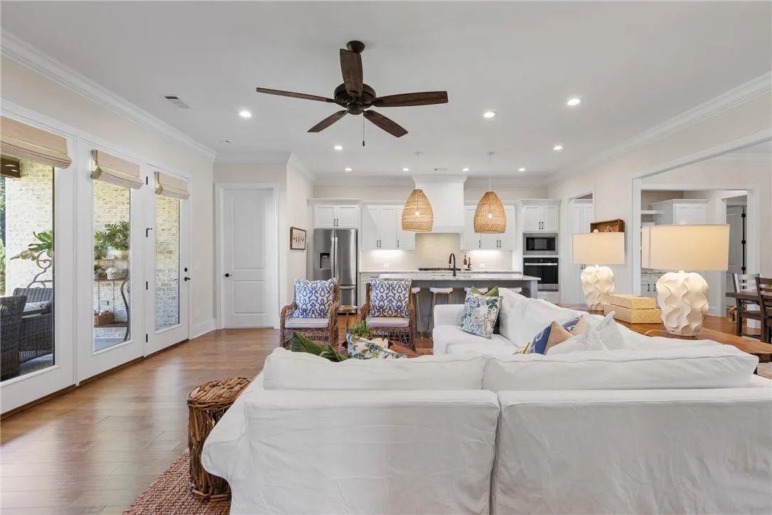 Crown molding and rich wood floors flow through this welcoming open-concept living area.