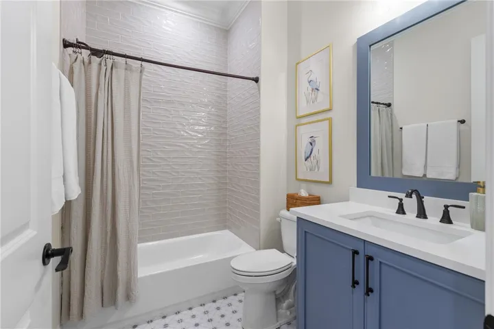 Gleaming tile surrounds the tub alongside a modern vanity with integrated sink.