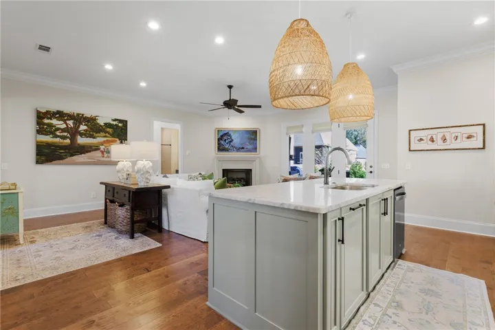 Polished stone countertops and rich wood flooring anchor this seamless open interior concept.