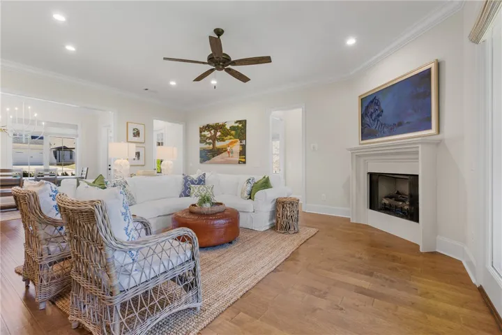 Rich hardwood flooring complements the classic fireplace mantel in this open living space.